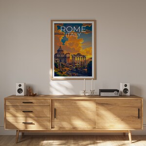 May include: A wooden cabinet with three drawers and two doors. The cabinet is in a room with a white wall and a framed poster of the Roman Forum with the text "ROME ITALY" above the image. There are two speakers and a stereo system on top of the cabinet.