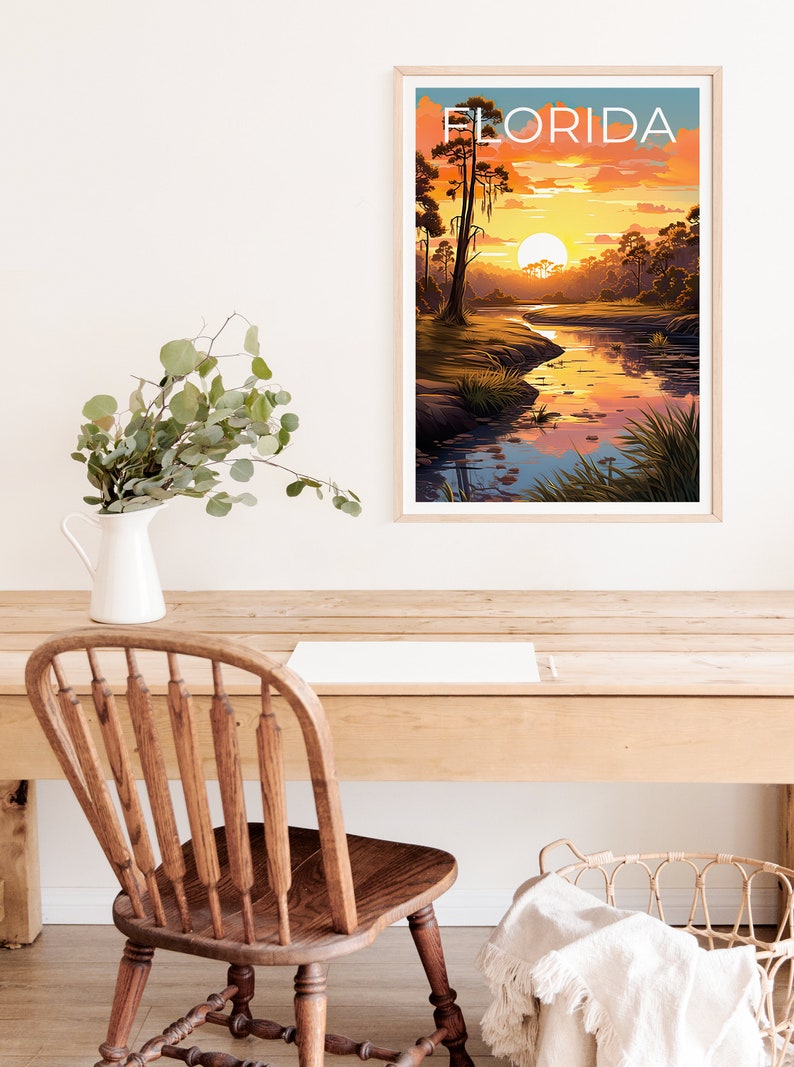 K&ouml;nnte beinhalten: Ein Vintage-Poster mit dem Wort "FLORIDA" in wei&szlig;er Schrift auf blauem Hintergrund. Das Poster zeigt einen Sonnenuntergang &uuml;ber einem Fluss in einem Sumpfgebiet mit hohen B&auml;umen und einer gro&szlig;en, orangen Sonne.