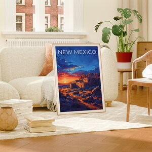 May include: A framed poster with a sunset scene of a pueblo in New Mexico. The poster has the text "NEW MEXICO" at the top.