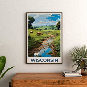 May include: A framed art print featuring a scenic landscape of Wisconsin. The artwork depicts a stream flowing through green fields, with cows grazing in the distance under a blue sky. The word "WISCONSIN" is printed in navy blue at the bottom.