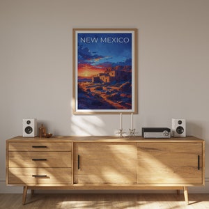 May include: A framed poster with a sunset scene and the text "NEW MEXICO" in white. The poster is hanging on a wall above a wooden cabinet with two speakers and a stereo system.