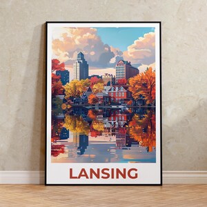 Puede incluir: Una impresión artística enmarcada que presenta una colorida ilustración de un paisaje urbano con edificios, árboles y una masa de agua que refleja la escena. La palabra "LANSING" está impresa en rojo en la parte inferior.