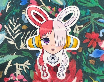 May include: A sticker featuring a cartoon character with red and white hair styled in a bunny ear shape. The character has purple eyes, a small nose, and a neutral expression. The sticker has a white border and is set against a floral background.