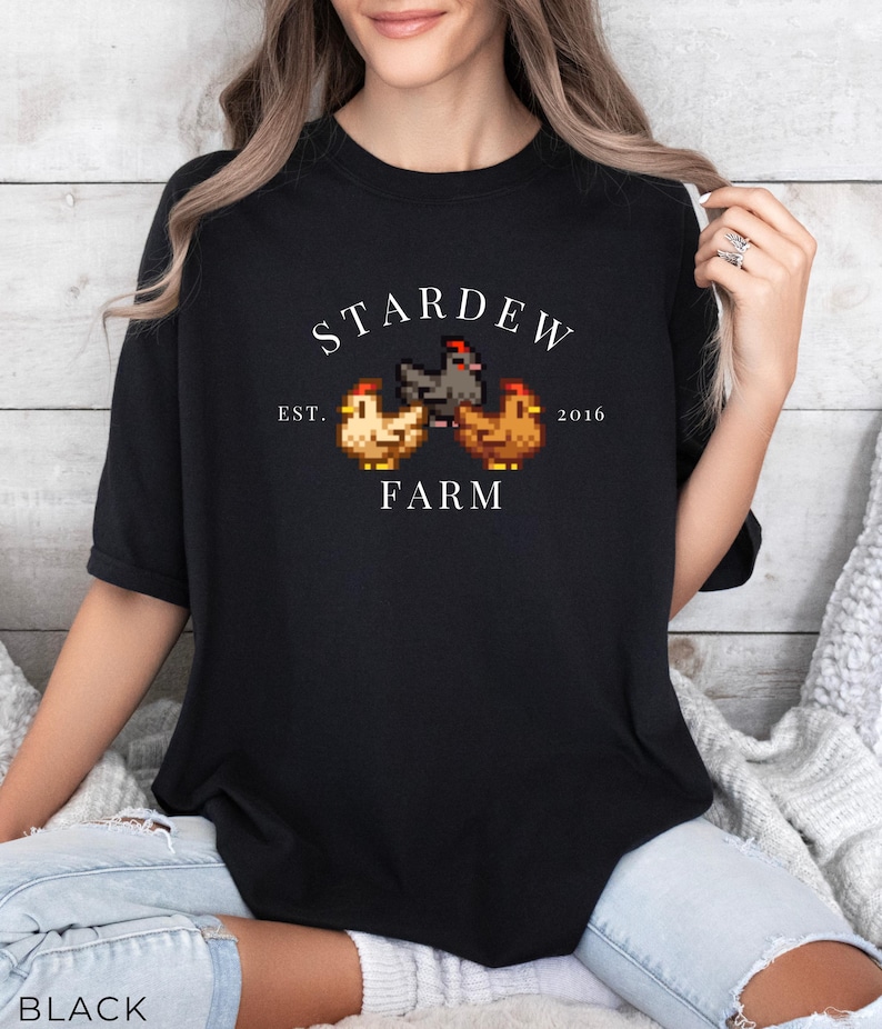 May include: Black t-shirt with a white graphic of three pixelated chickens and the text "Stardew Farm Est. 2016".