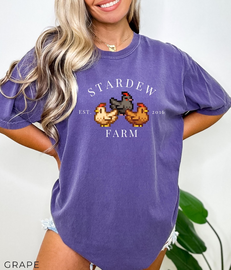 May include: Purple t-shirt with a white graphic of three chickens and the text "Stardew Farm Est. 2016".