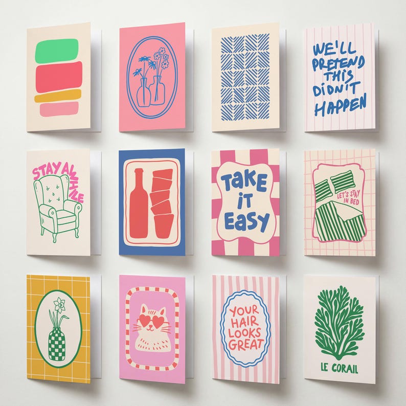 May include: A collection of twelve greeting cards arranged in a grid, featuring various colorful illustrations and text including 'We'll pretend this didn't happen', 'Stay awhile', 'Take it easy', 'Let's stay in bed', 'Your hair looks great', and 'Le corail'.