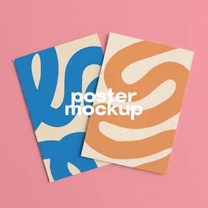 May include: Two rectangular posters with a cream background. The left poster features a bold blue abstract wavy line pattern. The right poster features a bold orange abstract wavy line pattern. The white text "poster mockup" is centered.