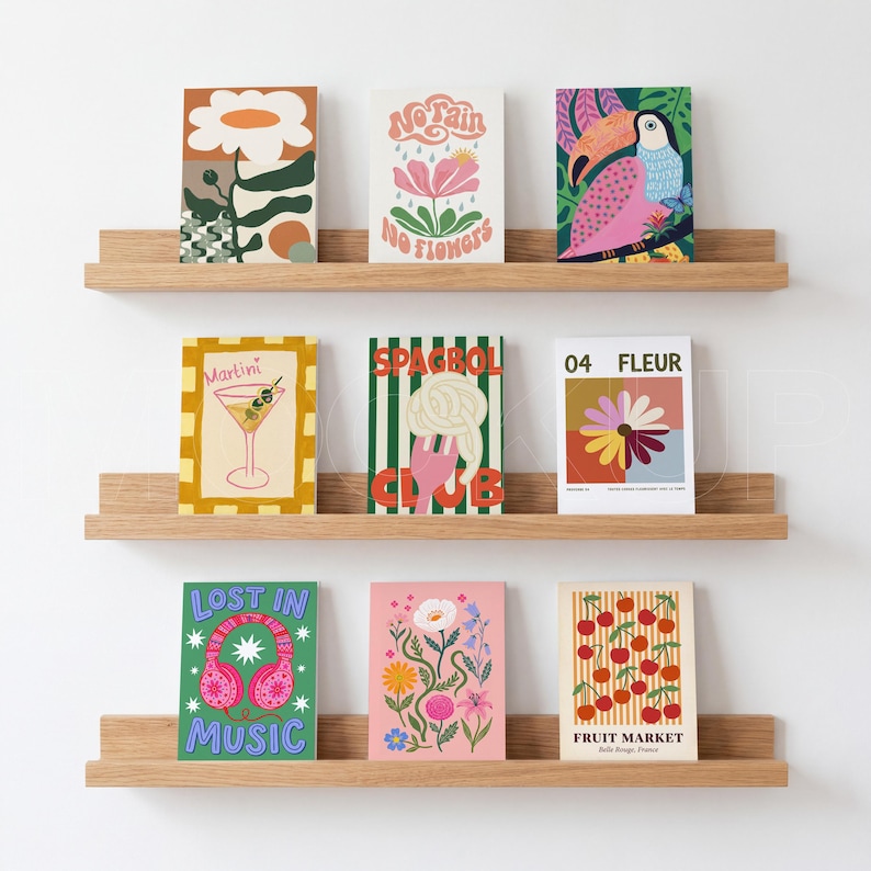 K&ouml;nnte beinhalten: Neun farbenfrohe Kunstdrucke auf Holzregalen vor einer wei&szlig;en Wand. Die Drucke zeigen verschiedene Illustrationen, darunter einen Martini, einen Papagei und die Worte "Lost in Music".