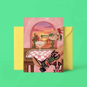 K&ouml;nnte beinhalten: Gru&szlig;karte mit Western-Thema. Die Illustration zeigt, wie Champagner in ein Glas gegossen wird, mit Cowboy-Stiefeln im Vordergrund. Die Stiefel sind schwarz mit Kaktus- und Sternmotiven. Die Karte wird von einem gelben Umschlag begleitet.