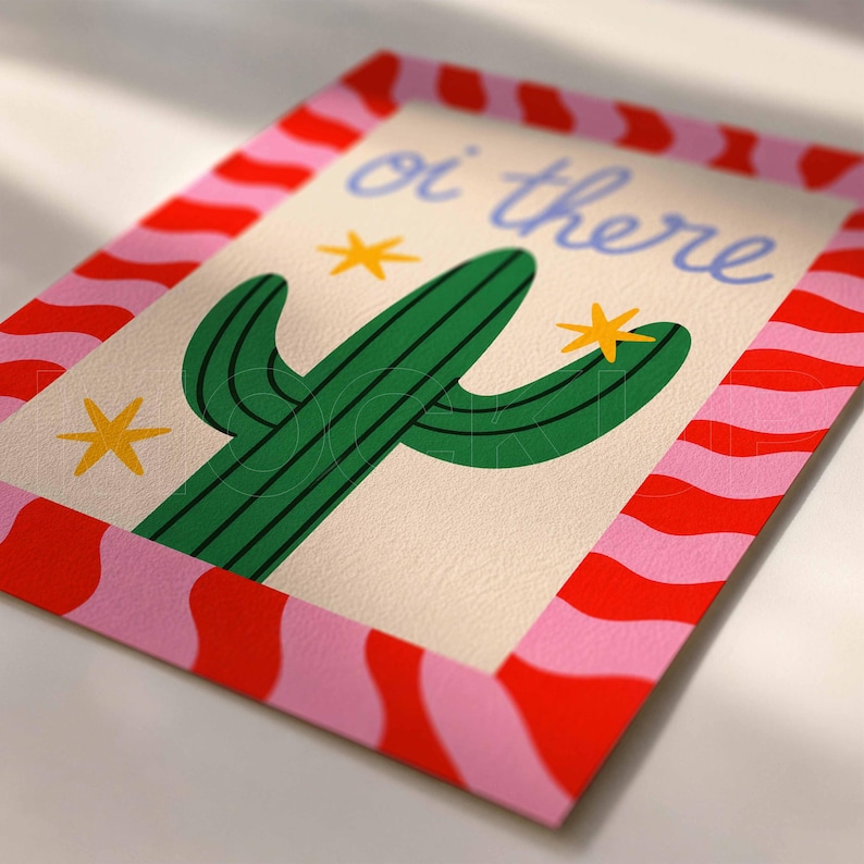 Peut inclure: Une impression rectangulaire repr&eacute;sentant un cactus vert sur fond cr&egrave;me avec le texte "oi there" en &eacute;criture bleue. Le motif comprend trois &eacute;toiles jaunes et est encadr&eacute; par une bordure de rayures verticales ondul&eacute;es rouges et roses.