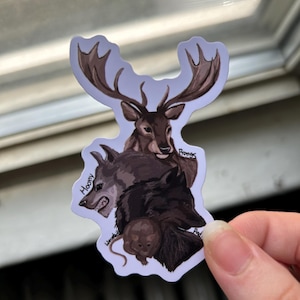 May include: A die-cut sticker featuring a stacked illustration of four animals: a brown stag at the top, a grey wolf, a black dog, and a small brown rat at the bottom. The text labels Moony, Prongs, Padfoot, and Wormtail are written near each animal.