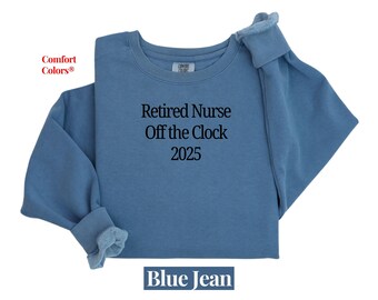 May include: Blue jean-colored sweatshirt with the text "Retired Nurse Off the Clock 2025." The sweatshirt is a crew neck style with long sleeves and a soft, textured appearance. The words "Comfort Colors" are in the upper left corner.