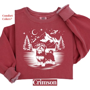 May include: Crimson-colored sweatshirt with a white graphic of a dog, mountains, trees, a crescent moon, stars, and a planet. The text "Comfort Colors" and "Crimson" are also visible.
