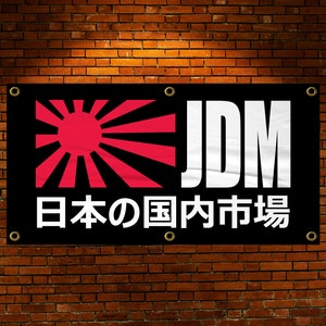 Könnte beinhalten: Schwarz-weißes Banner mit einer roten aufgehenden Sonne Grafik und dem Text "JDM" und "日本の国内市場" in weiß.