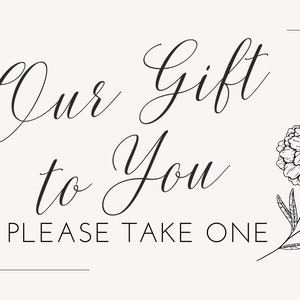 May include: Black and white calligraphy sign that reads "Our Gift to You Please Take One" with a black and white floral illustration.