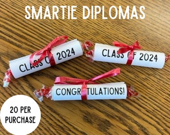 May include: A set of three white paper scrolls tied with red ribbon, each with black text. The scrolls say "Class of 2024" and "Congratulations!"  A white circle with black text says "20 per purchase".