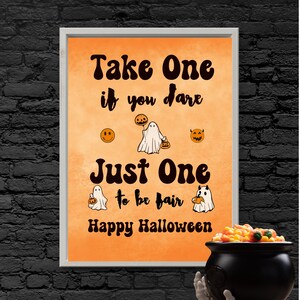 May include: Orange and white Halloween sign with the text "Take One if you dare Just One to be fair Happy Halloween". The sign features a ghost holding a pumpkin and a smiley face.