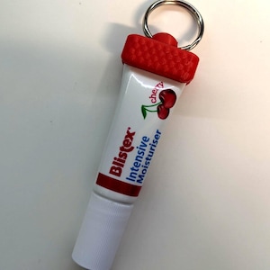 May include: A red and white tube of cherry flavoured Blistex Intensive Moisturiser attached to a silver keyring.
