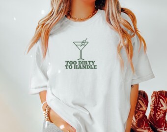 May include: White t-shirt with a green martini glass graphic and the text "Too Dirty To Handle".