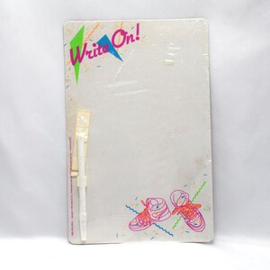 May include: White dry-erase board with a pink, blue, and green "Write On!" logo. The board has a white marker attached to the side and a colorful design of two sneakers at the bottom.