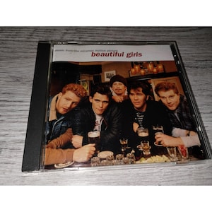 May include: A CD case featuring the movie title "beautiful girls" with a group of men seated at a bar. The CD case is black, and the cover art shows the film's cast. The text "music from the miramax motion picture" is also visible.