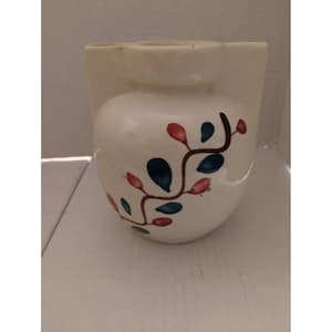May include: White ceramic pitcher with a floral design. The pitcher has a brown vine with blue leaves and pink flowers.
