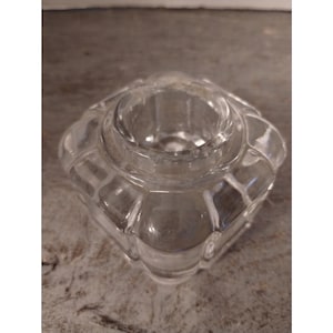 May include: A clear glass inkwell with a square base and a textured, faceted design.