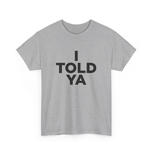 May include: A heather grey t-shirt with black text that reads "I TOLD YA".