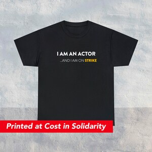 Puede incluir: Camiseta negra con texto blanco que dice "I AM AN ACTOR...AND I AM ON STRIKE". El texto "STRIKE" está en amarillo. El texto está impreso en una camiseta negra. La camiseta se imprime al costo en solidaridad.