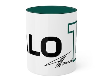 May include: White ceramic mug with a dark green interior and rim. The mug features the word "ALO" in bold black letters, the number "7" in green, and a signature in black. A simple, yet stylish design.