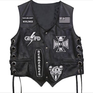 以下が含まれることがあります： 黒い革ベスト。複数のワッペン付き。「BLACK LABEL SOCIETY WORLDWIDE」、「GIOFD」のスカルと稲妻、「DOOM CREW INC.」、「BERSERKER」、旗のデザインの「BLS」など。ベストはサイドレースと金属製のアイレットが付いています。