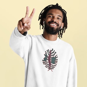 May include: A white sweatshirt with a green and red abstract leaf design.
