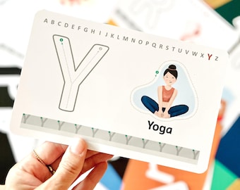 May include: A rectangular educational flashcard featuring the letter Y in a large outline font, an alphabet sequence at the top, and an illustration of a person in a seated pose with the text Yoga below. A row of smaller Y letters is at the bottom.