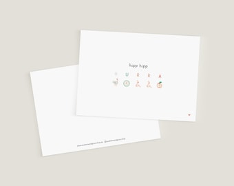 May include: A white card with the text "hipp hipp" and the letters "HURRA" spelled out with illustrations of a chicken, clock, worm, worm, and an apple.