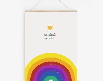 May include: A framed art print featuring a yellow sun and a rainbow. The text "Ich glaube an mich" is written in colorful letters. The print is hung by a wooden bar and a string.