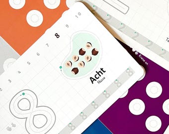 May include: A white card with a grid pattern and the number 8 written in a dotted line. The card also has a picture of eight hazelnuts in a green shell. The text "Acht Nüsse" is written below the picture. The card is part of a set of cards for learning numbers.