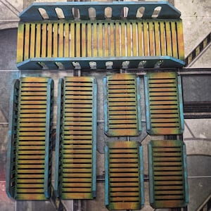May include: A set of six blue and brown wooden bridge pieces for a tabletop game or miniature wargaming terrain. The pieces are designed to be used together to create a bridge.