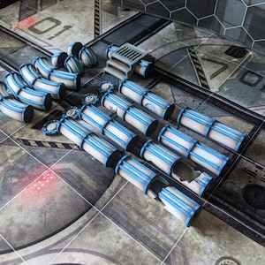 May include: A set of white and blue plastic pipes with a blue and white striped design. The pipes are arranged in a row on a gray and black tiled surface.