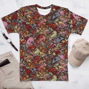 Puede incluir: Una camiseta blanca con un estampado colorido de varias criaturas marinas, incluyendo calamares, pulpos y medusas. El estampado es un patrón ajetreado con mucho detalle.