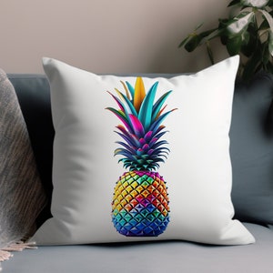 May include: A white pillow with a colorful pineapple design. The pineapple is made up of different shades of blue, green, yellow, orange, and red. The pineapple is sitting on a white background.