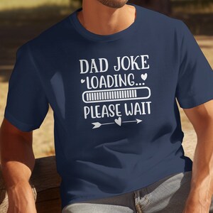 May include: A navy blue t-shirt with a white graphic that says "Dad Joke Loading... Please Wait" with a progress bar and two hearts.