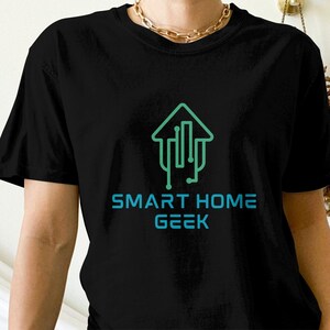 May include: Black t-shirt with a green and blue graphic of a house with circuit board lines inside. The text "SMART HOME GEEK" is printed below the graphic.