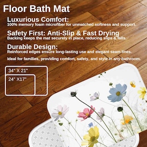 May include: White bath mat with a floral design featuring pink, yellow, and blue flowers. The mat has a textured backing and is available in two sizes: 86 cm by 53 cm and 61 cm by 43 cm.