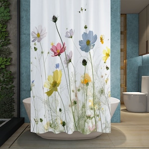 May include: White shower curtain with a floral print featuring pink, yellow, blue, and white cosmos flowers on a white background.