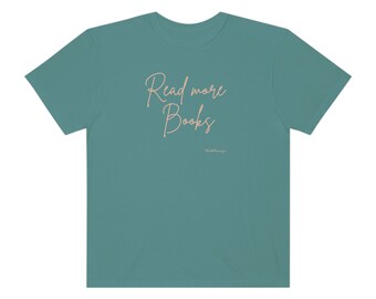 以下が含まれることがあります： 「Read more Books」の文字が筆記体で書かれた、ティール色のTシャツ。Tシャツには、小さなフォントで「charlie&amp;company」の文字も入っています。柔らかく快適な素材で作られています。