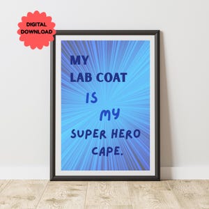 Op de afbeelding: Een ingelijste print met de tekst "MY LAB COAT IS MY SUPER HERO CAPE" in blauw tegen een blauwe radiale burst-achtergrond. Een rode "DIGITAL DOWNLOAD" sticker staat in de linkerbovenhoek. De lijst is zwart.