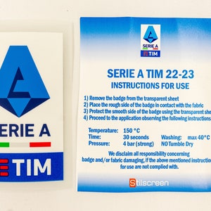 Op de afbeelding: Een blauwe en witte sticker met het Serie A-logo en de tekst "Serie A TIM 22-23" en gebruiksaanwijzingen. De instructies omvatten de temperatuur, de tijd, de druk en de wasinstructies. De tekst "Stilscreen" staat onderaan de sticker.