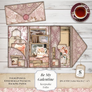 Op de afbeelding: Een vintage-stijl keepsake folio met een bloemenontwerp in roze en crème tinten. De folio bevat zakken, ephemera en achtergrondpapier. De afbeelding toont ook een envelop, een theekopje en de tekst "Be My Galentine".