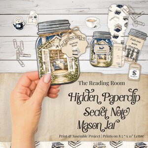 Peut inclure: Un projet de bricolage en papier comprenant un motif de bocal Mason avec une illustration de salle de lecture, une étiquette marquée The Book Nook, et un second bocal avec le texte Just one more chapter has ruined many bedtimes. Inclut des trombones.