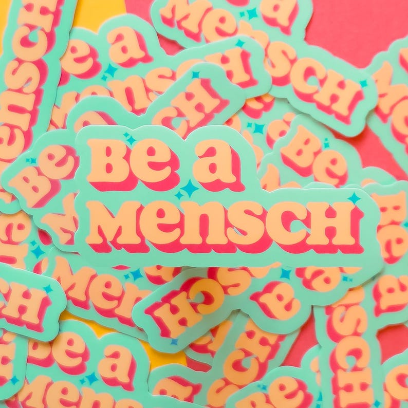 K&ouml;nnte beinhalten: Eine Ansammlung von Aufklebern mit dem Schriftzug "Be a Mensch" in Orange, umrandet in Rot, auf hellgr&uuml;nem Hintergrund. Die Aufkleber haben eine Retro-Schriftart und sind auf einem bunten Hintergrund verteilt.